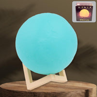 A serene blue Moon Night Lamp illuminating a dark room, creating a calming ambiance.