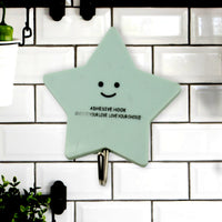 A set of strong self-adhesive hooks displayed neatly on a tiled kitchen wall, ready for use.