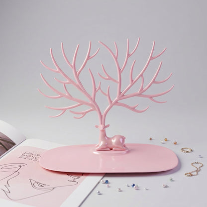 Front view of pink deer jewelry stand with earrings and rings, India