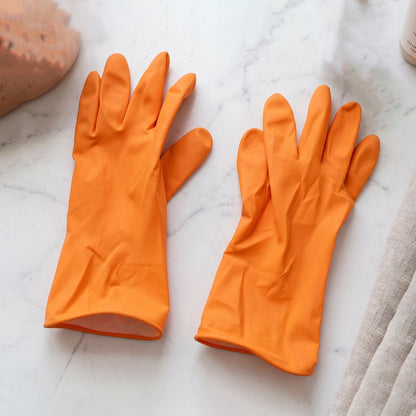 Reusable orange rubber household cleaning gloves laid out