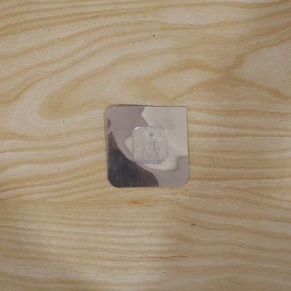 Self adhesive wall hook securely holding items in a home setting.